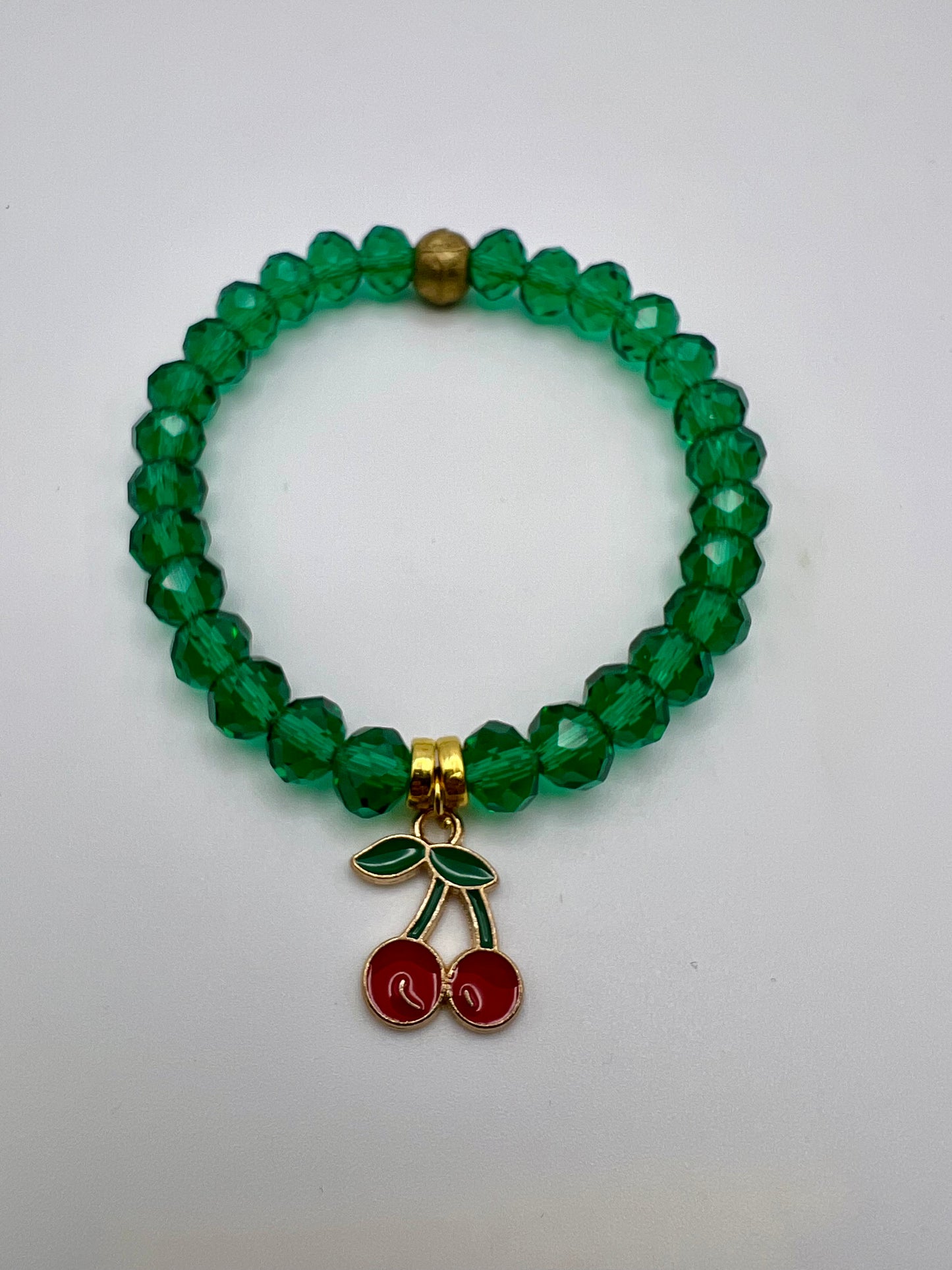 Green faceted crystal with cherry charm and brass spacer.